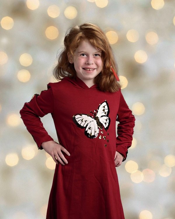Evelyn Shanahan, smiling in her red butterfly dress